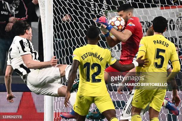 Villarreal's Argentinian goalkeeper Geronimo Rulli grabs a shot from Juventus' Serbian forward Dusan Vlahovic during the UEFA Champions League round...