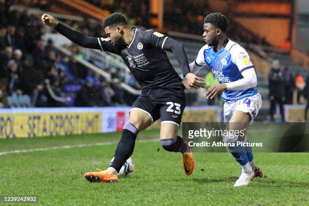 Cyrus Christie of Swansea City is challenged by Bali Mumba of Peterborough during the Sky Bet Championship match between Peterborough United and...