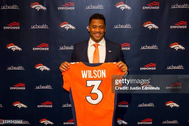 Quarterback Russell Wilson of the Denver Broncos poses with his jersey after speaking to the media at UCHealth Training Center on March 16, 2022 in...