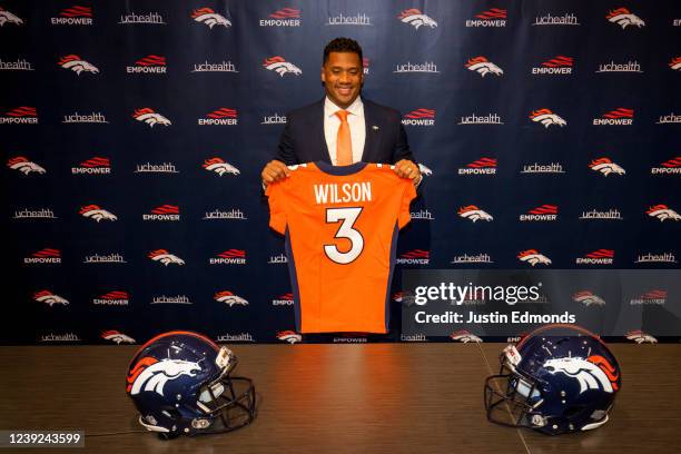 Quarterback Russell Wilson of the Denver Broncos poses with his jersey after speaking to the media at UCHealth Training Center on March 16, 2022 in...