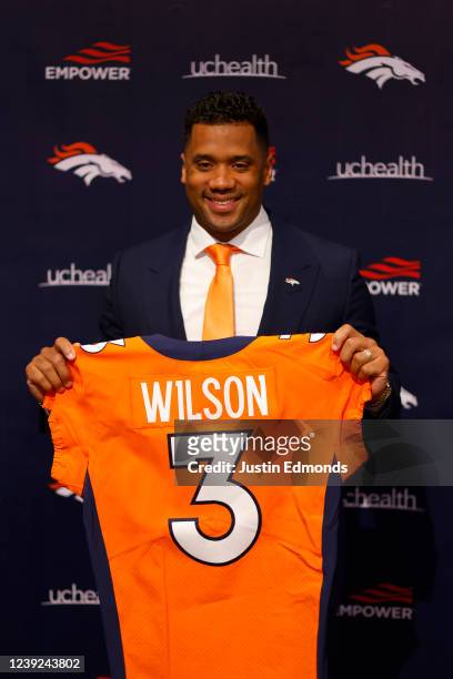Quarterback Russell Wilson of the Denver Broncos poses with his jersey after speaking to the media at UCHealth Training Center on March 16, 2022 in...