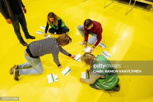 Employees of a polling station work during the vote counting of the municipal elections at a polling station in Rotterdam, on March 16, 2022. -...