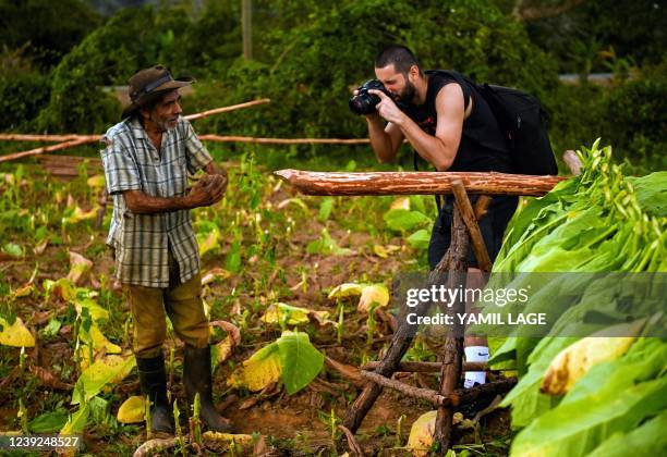 Tourist takes pictures of a tobacco producer in Vinales, Pinar del Rio province, Cuba, on February 19, 2022. - Vinales, a town with an incipient...