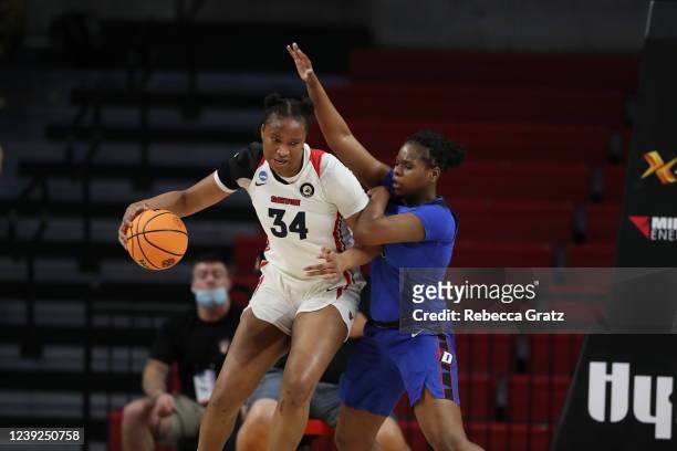 Tenin Magassa of the the Dayton Flyers drives to the basket despite defensive efforts by Darrione Rogers of the DePaul Blue Demons during the First...