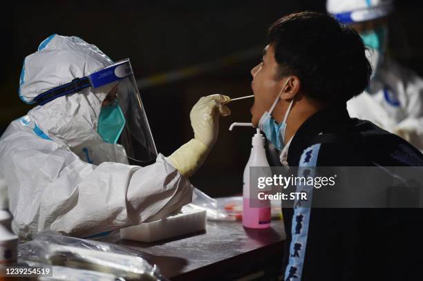 This photo taken on March 16, 2022 shows a resident undergoing a nucleic acid test for the Covid-19 coronavirus in Nanjing in China's eastern Jiangsu...