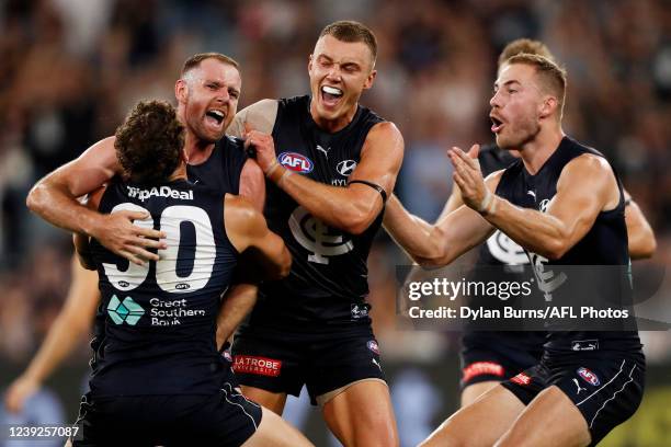 Sam Docherty of the Blues celebrates a goal with Charlie Curnow, Harry McKay and Patrick Cripps of the Blues during the 2022 AFL Round 01 match...