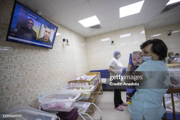 Baby is seen in the arms of a woman in Kyiv, Ukraine on March 17, 2022. Surrogate-born babies cannot reunite with their biological families due to...