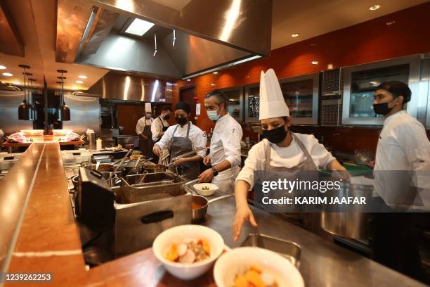 Kitchen crew work on the line at the JW Marriott Marquis hotel in the Qatari capital Doha on March 16, 2022. - Fans have sought 17 million tickets...