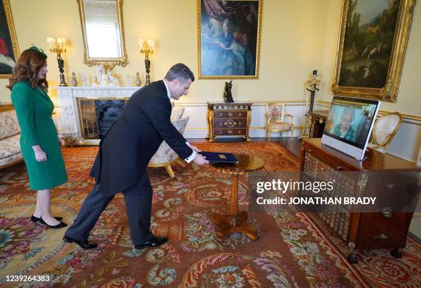 Britain's Queen Elizabeth II appears on a screen via videolink from Windsor Castle, during a virtual audience to receive Kosovo's Ambassador to the...