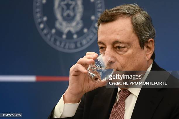 Italy's Prime Minister, Mario Draghi drinks water as he speaks about a planned lifting of the country's Covid-19 state of emergency and rules imposed...