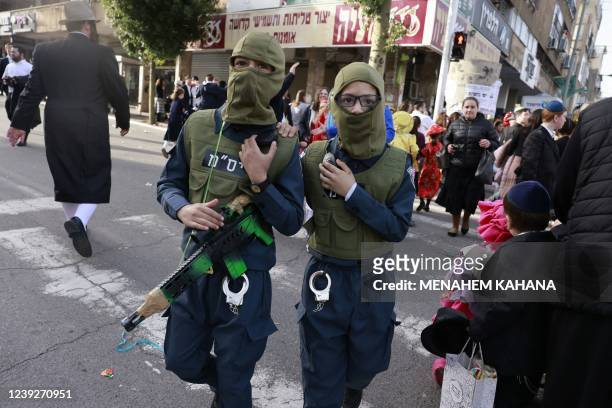 Ultra-Orthodox Jewish youths in Purim costumes celebrate in the Israeli city of Bnei Brak on March 17, 2022. - The carnival-like Purim holiday is...