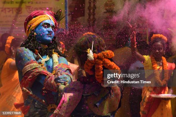 People dressed as Hindu deity Lord Krishna and Radha smeared with coloured powder, dance to celebrate Holi festival on March 17, 2022 in Kolkata,...