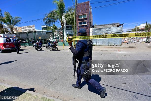 Policeman secures the area where a man was murdered inside his truck in Fresnillo, in Zacatecas state, Mexico, on March 15, 2022. - Since 2020, the...