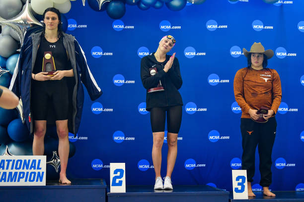 University of Pennsylvania swimmer Lia Thomas accepts the winning trophy for the 500 Freestyle finals as second place finisher Emma Weyant and third...