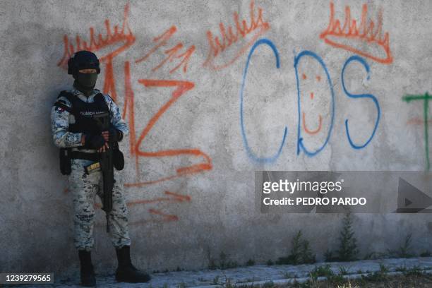 Mexican soldier stands guard next to some graffitis of the drug trafficker Mayo Zambada and the criminal group "Cartel de Sinaloa" , in Palmas Altas...