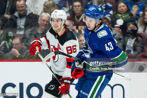 Vancouver Canucks defenseman Quinn Hughes and New Jersey Devils center Jack Hughes after a whistle during their NHL game at Rogers Arena on March 15,...