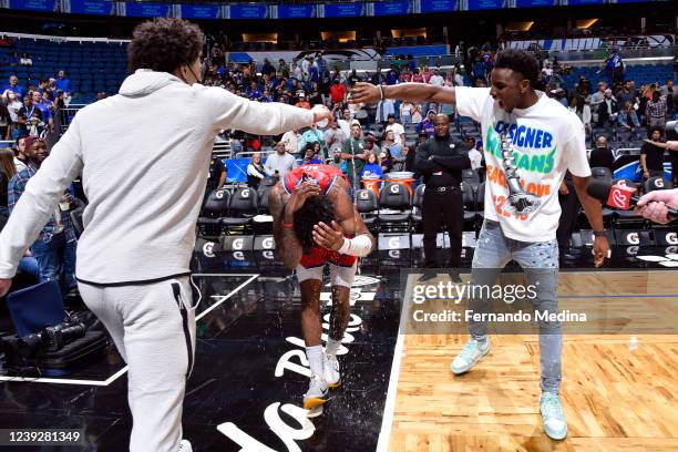 Cade Cunningham and Hamidou Diallo celebrate with Saddiq Bey of the Detroit Pistons after the game against the Orlando Magic on March 17, 2022 at...
