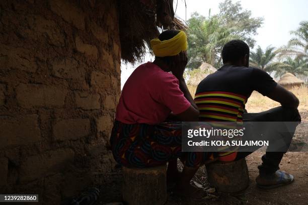 Cameroonian refugee couple that ran away with dozens of others to a Nigerian village, sits beside their makeshift hut inside Manga village, that...