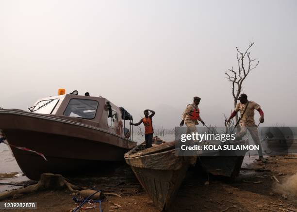 Nigerian Immigration Marine officers disembark from a boat at Manga, a village that borders Nigeria and Cameroon, on January 28, 2022 weeks after...