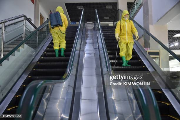 Employees spray disinfectant as part of preventative measures against the Covid-19 coronavirus at the Pyongyang Children's Department Store in...