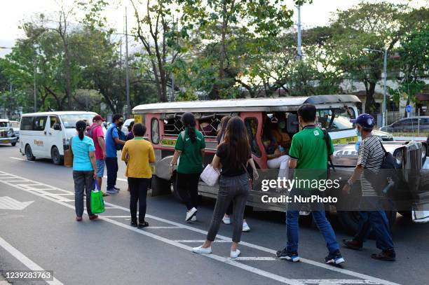 In this picture taken on 9 March 2022, passengers attempt to board a jeepney, a unique type of public transport in the Philippines, as commuters wait...