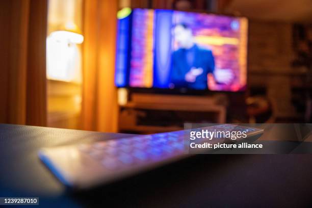 March 2022, North Rhine-Westphalia, Bad Oeynhausen: ILLUSTRATION - A remote control is lying in front of a TV. Photo: Lino Mirgeler/dpa
