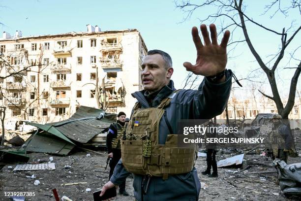 Kyiv's mayor Vitali Klitschko holds people away from a five-storey residential building that partially collapsed after a shelling in Kyiv on March 18...