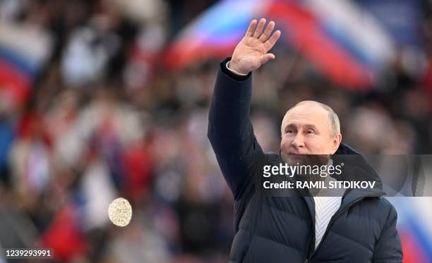 Russian President Vladimir Putin waves during a concert marking the eighth anniversary of Russia's annexation of Crimea at the Luzhniki stadium in...