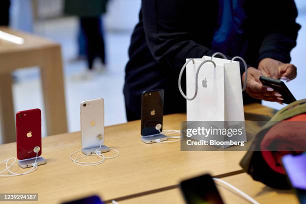 Customer buys an Apple iPhone SE 3 smartphone during the sales launch at the Apple Inc. Flagship store in New York, U.S., on Friday, March 18, 2022....