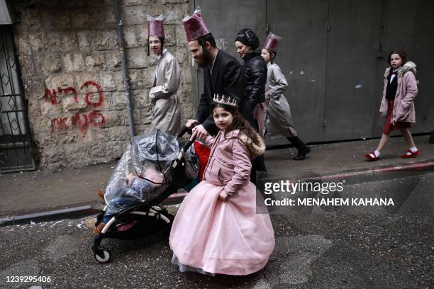 Jewish men and children in Purim costumes celebrate in the Mea Shearim ultra-Orthodox neighbourhood in Jerusalem, on March 18, 2022. - The...