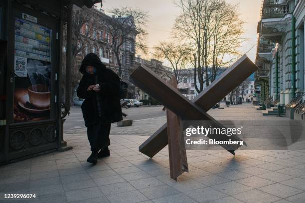 Pedestrian passes an anti-tank obstacle on a sidewalk in the center of Odesa, Ukraine, on Friday, March 18, 2022. While Russian landing craft have...