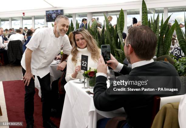 Michel Roux Jr. Poses for a photo with a guest in the Chez Roux restaurant during day four of the Cheltenham Festival at Cheltenham Racecourse....