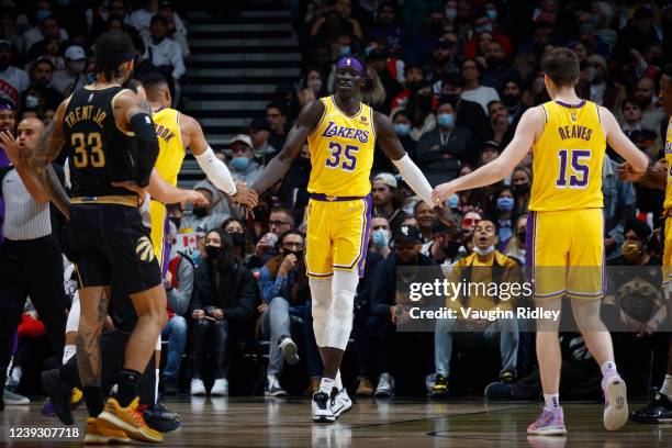 Wenyen Gabriel of the Los Angeles Lakers high fives Austin Reaves of the Los Angeles Lakers and Russell Westbrook of the Los Angeles Lakers during...