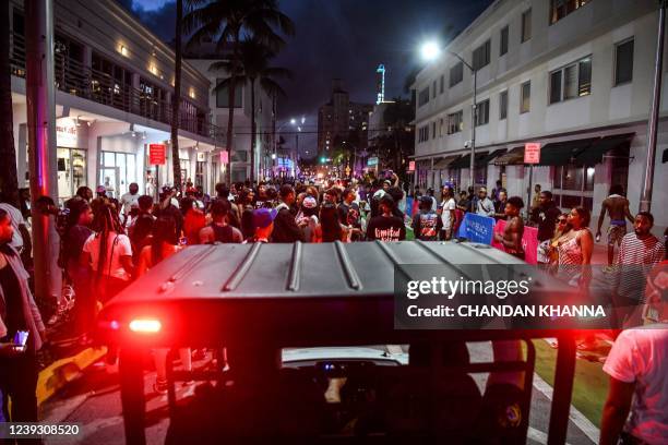 Miami Beach Police escort revelers as they gather on Ocean Drive in Miami Beach, Florida on March 15, 2022. - Music, dancing, alcohol and tiny...