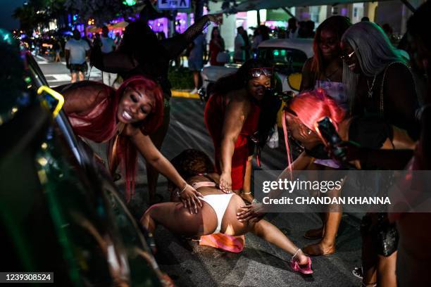 Revelers dance on Ocean Drive in Miami Beach, Florida, March 17, 2022. - Music, dancing, alcohol and tiny swimsuits -- spring vacation in the United...