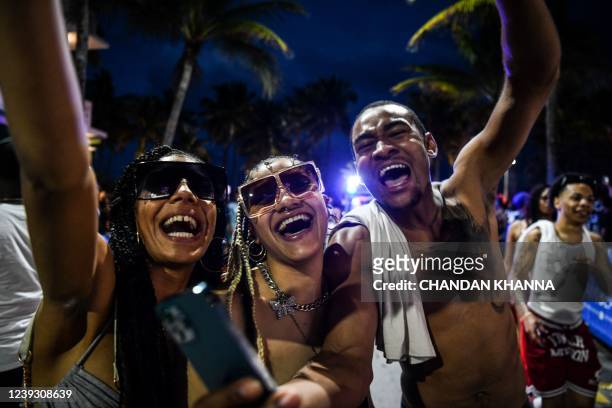 Revelers dance on Ocean Drive in Miami Beach, Florida, March 15, 2022. - Music, dancing, alcohol and tiny swimsuits -- spring vacation in the United...