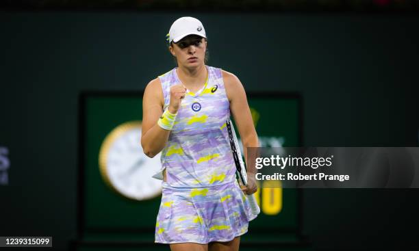 Iga Swiatek of Poland celebrates winning a point against Simona Halep of Romania in her semi-final match at the 2022 BNP Paribas Open at the Indian...