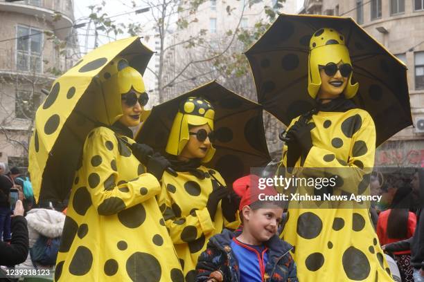 Boy poses for photos with performers during the Jewish holiday of Purim in Jerusalem, on March 18, 2022. Purim is a Jewish holiday that commemorates...