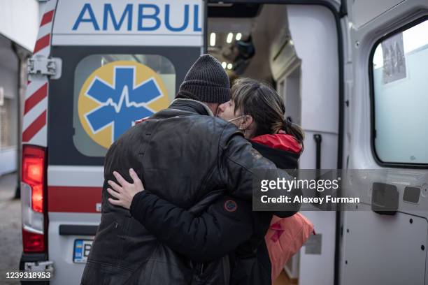 Man hugs his wife next to an ambulance car that would evacuate her and her daughter to Poland on March 19, 2022 in Lviv, Ukraine. The evacuation...