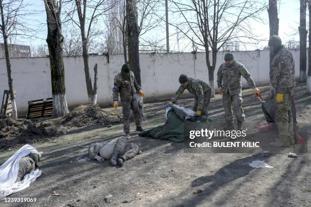 Graphic content / Ukrainian soldiers cover bodies of dead soldiers laying next to the military school hit by Russian rockets the day before, in...