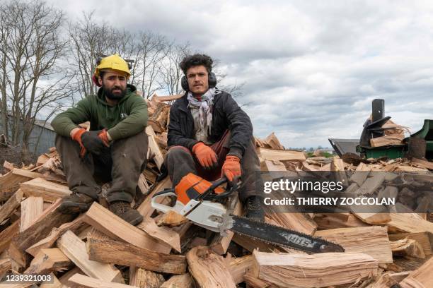 Matiullah Mehrabi and Sherbaz Safizada , two Afghan refugees who found a job in a sawmill pose in Aigueperse, centre France, on February 24, 2022. -...