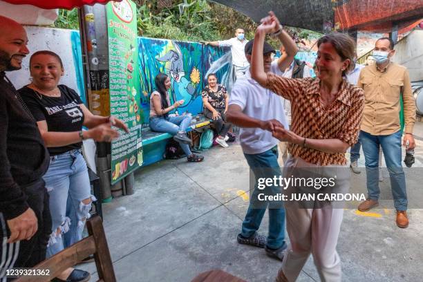 Colombian Presidential candidate, French-Colombian Ingrid Betancourt of Verde Oxigeno party dances with a man at the Comuna 13 neighbourhood during...