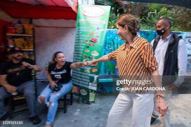 Colombian Presidential candidate, French-Colombian Ingrid Betancourt of Verde Oxigeno party greets a woman at the Comuna 13 neighbourhood during her...