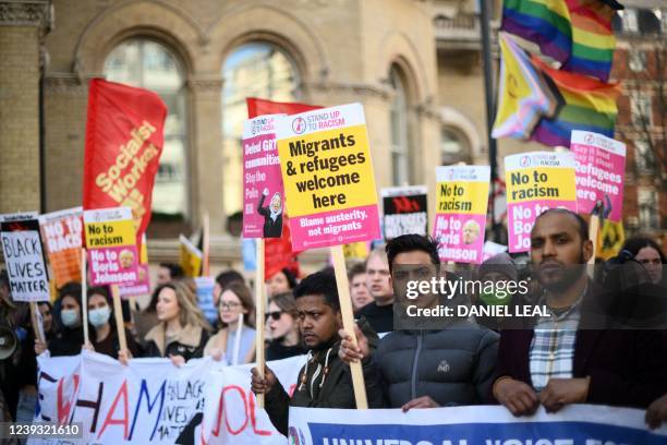 Protesters hold up placards at a March Against Racism in central London on March 19 to support UN Anti-Racism Day. - UN Anti Racism Day will see...