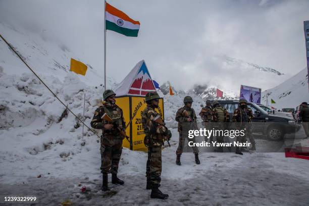 Indian army soldiers stand guard at the snow-cleared Srinagar-Leh highway on March 19, 2022 in Zojila, 108 km the Pass was opened this year after a...