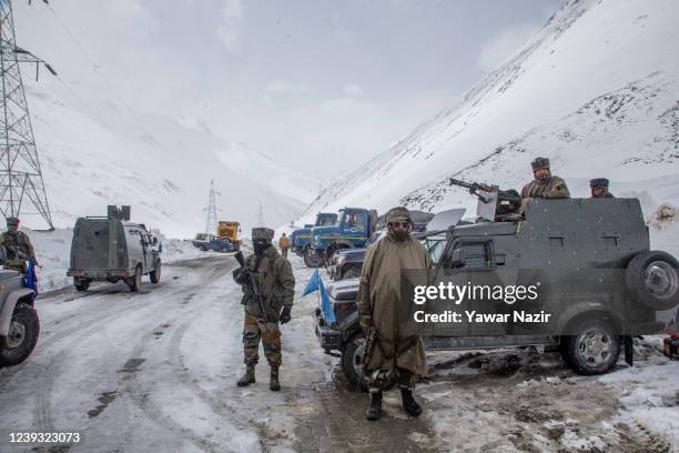 Indian army soldiers stand guard at the snow-cleared Srinagar-Leh highway on March 19, 2022 in Zojila, 108 km the Pass was opened this year after a...