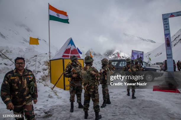 Indian army soldiers stand guard at the snow-cleared Srinagar-Leh highway on March 19, 2022 in Zojila, 108 km the Pass was opened this year after a...