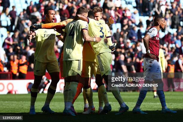 Arsenal's players celebrate next to Aston Villa's English defender Ashley Young at the end of the English Premier League football match between Aston...