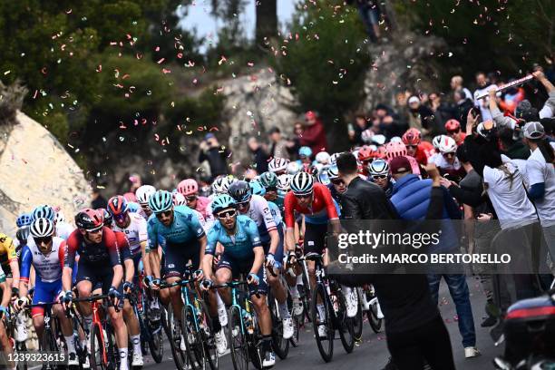 Spectators cheer as the pack rides the ascent of Capo Berta, Imperia, during the 113th Milan-San Remo one-day classic cycling race, on March 19, 2022...