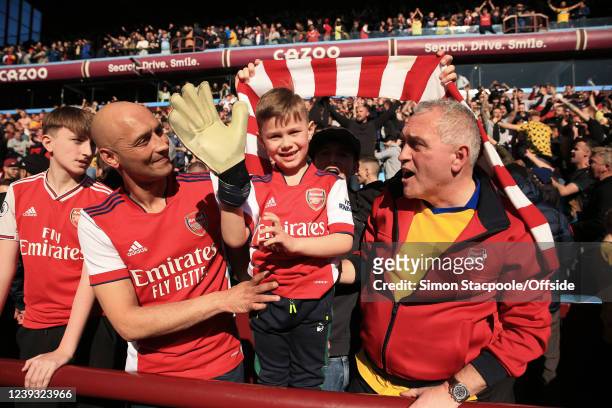 Young Arsenal fan tries on the glove given to him by Arsenal goalkeeper Bernd Leno after the Premier League match between Aston Villa and Arsenal at...